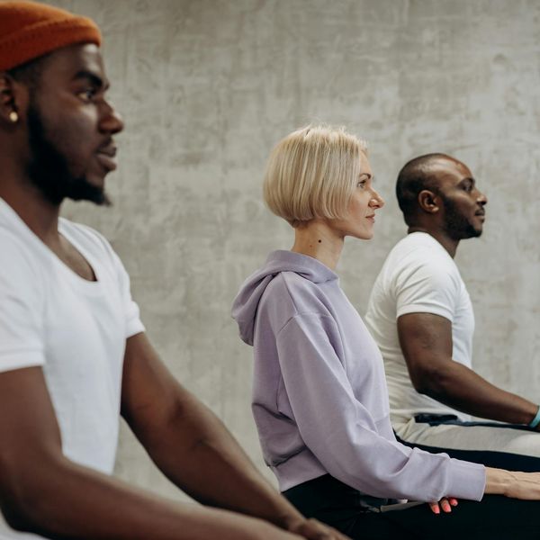 Diverse group of people practicing yoga together, smiling.